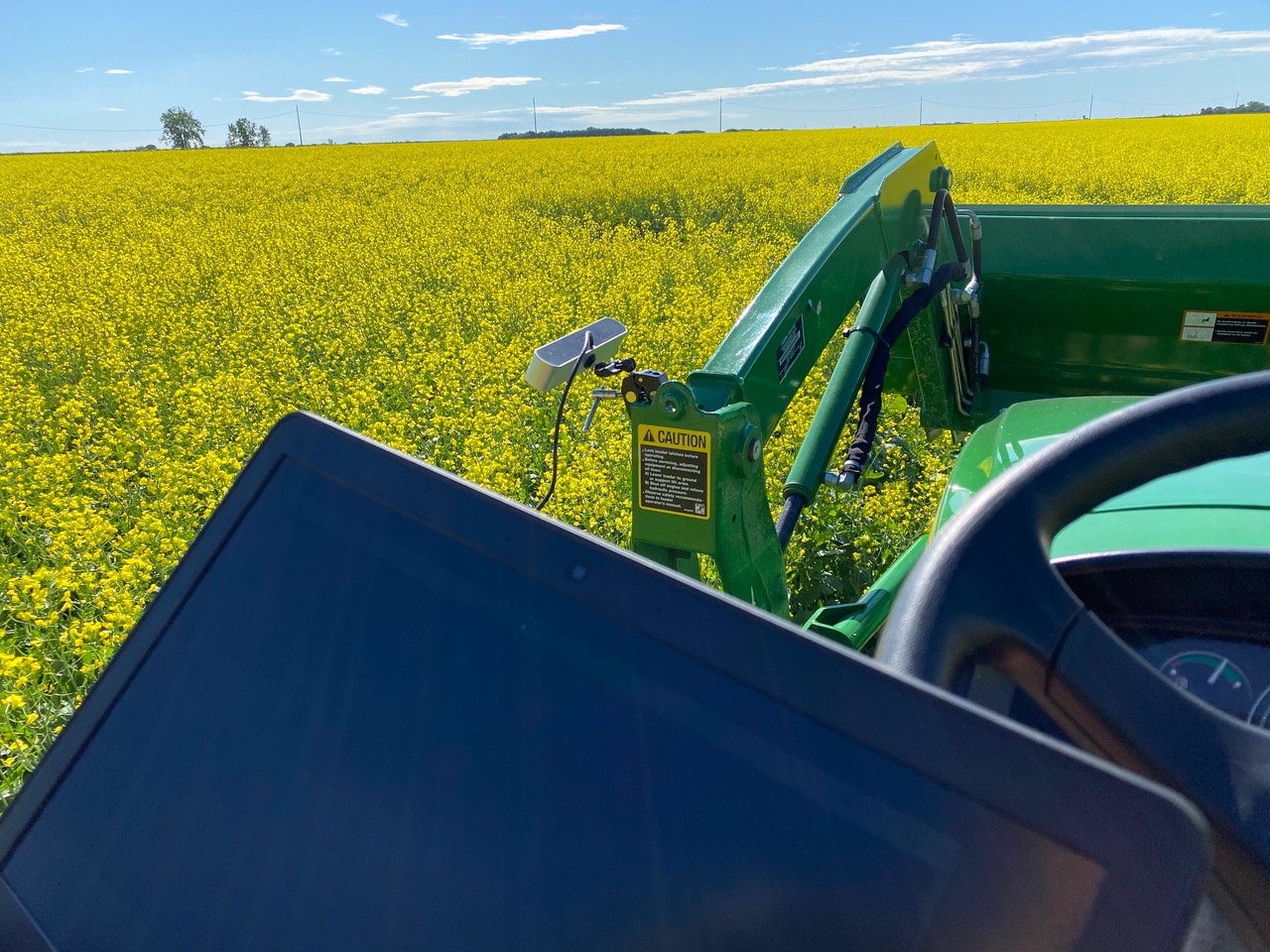 Tablette utilisée pour évaluer et surveiller les conditions dans un champ, prise du point de vue d’un agriculteur sur un tracteu